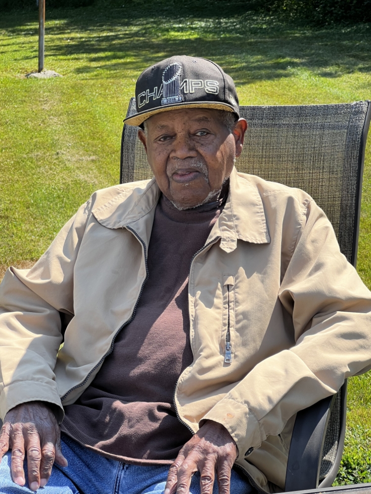 A picture of Noland Harry Sampson, Sr. sitting outside in a chair